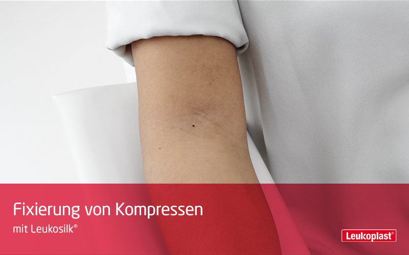 Hier sehen Sie in einem Close-Up-Video, wie Kompressen mit Hilfe des hautfreundlichen Rollenpflasters fixiert werden können: Das Fachpersonal platziert eine Kompresse in der Armbeuge des Patienten und fixiert diese mit dem Leukosilk® Rollenpflaster. Hier sehen Sie in einem Close-Up-Video, wie Kompressen mit Hilfe des hautfreundlichen Rollenpflasters fixiert werden können: Das Fachpersonal platziert eine Kompresse in der Armbeuge des Patienten und fixiert diese mit dem Leukosilk® Rollenpflaster.